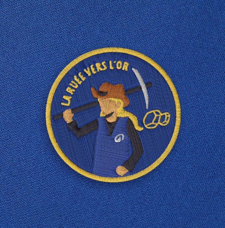 Broderie femme bleu nuit du visuel La ruée vers l'or sur fond bleu.