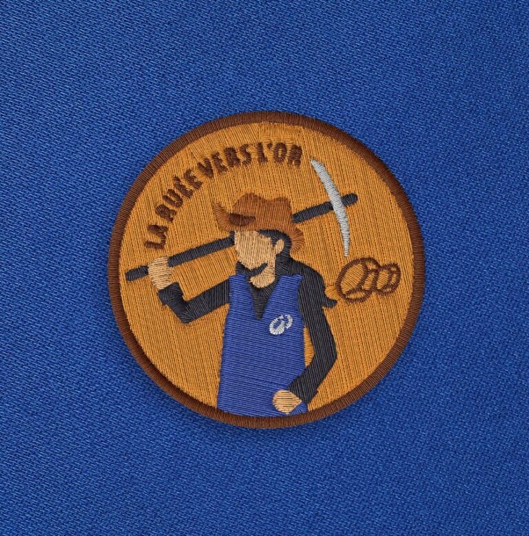 Broderie femme marron du visuel La ruée vers l'or sur fond bleu.