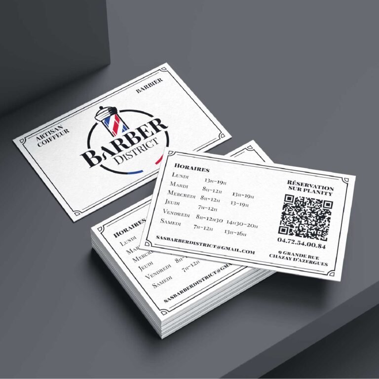 Cartes de visite Barber District empilées sur fond gris.