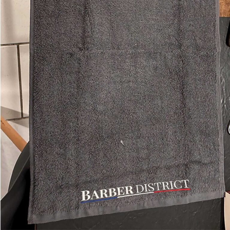 Serviette noire Barber District avec logo brodé en bas à droite.