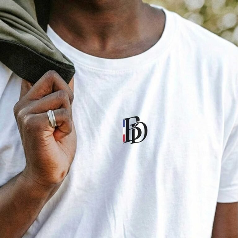T-shirt blanc Barber District porté avec logo monogramme sur la poitrine.
