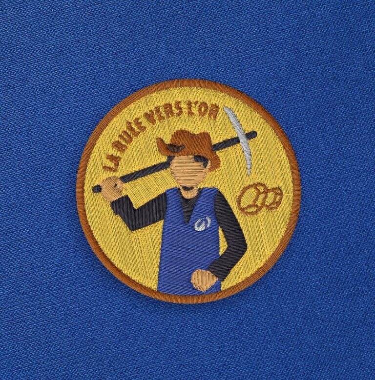 Broderie homme jaune du visuel La ruée vers l'or sur fond bleu.