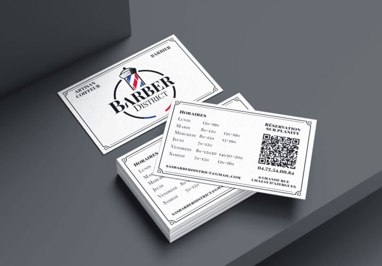 Cartes de visite Barber District empilées sur fond gris.