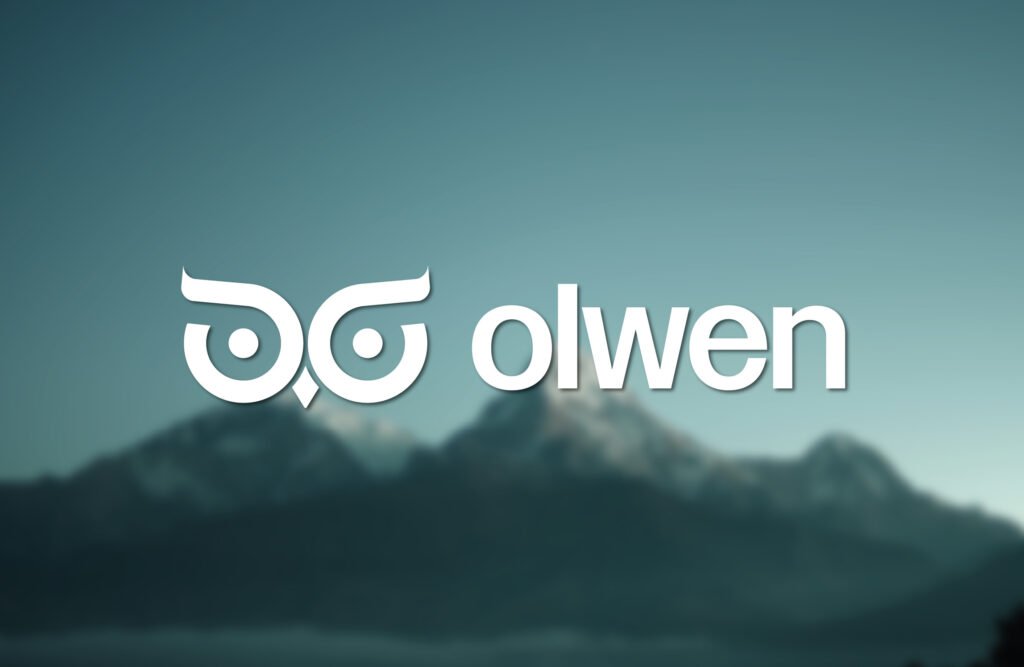 Logo de l'agence Olwen posé sur un fond montagneux et avec un léger flou.