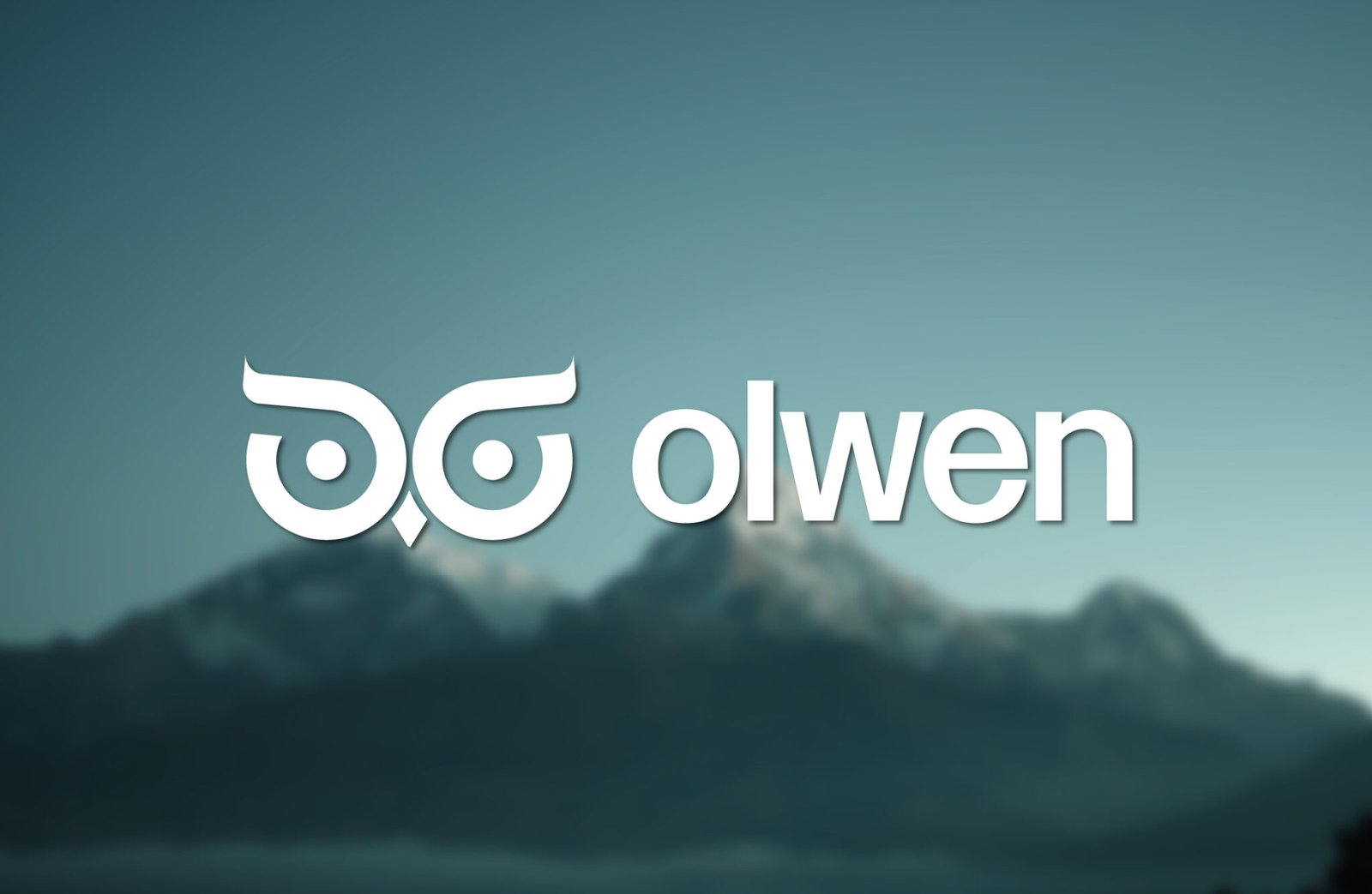 Logo de l'agence Olwen posé sur un fond montagneux et avec un léger flou.