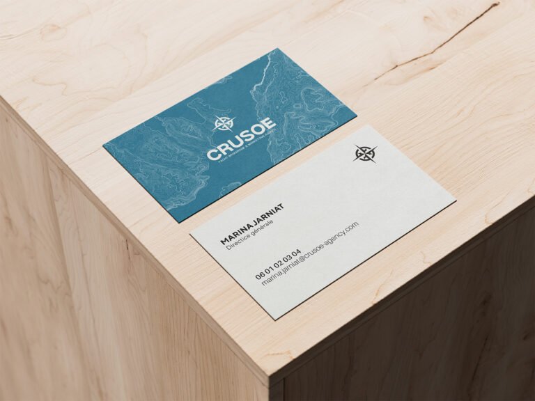 Cartes de visite Crusoe posées sur un support en bois.