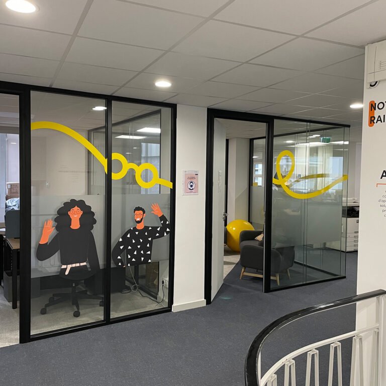 Entrée de bureaux vitrés avec marquage graphique jaune sur les cloisons en verre.