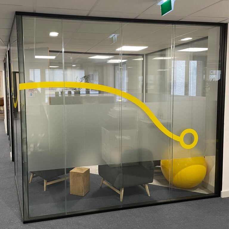 Bureau vitré avec vitrage dépoli partiel et ligne graphique jaune sur la paroi.